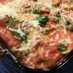 Close up shot of ravioli bake in pan with a blue background.