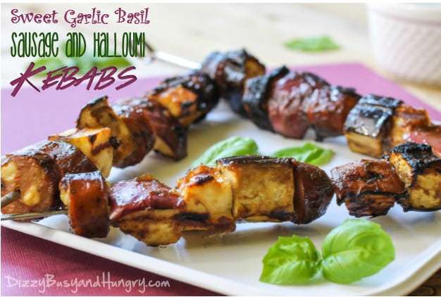 Close up shot of sweet garlic basil sausage and halloumi kebabs on a white plate on a red cloth. 