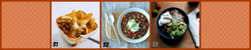 Overhead shot of vegetarian chili topped with sour cream and chives in white bowl on a cutting board with a spoon and a white background. 