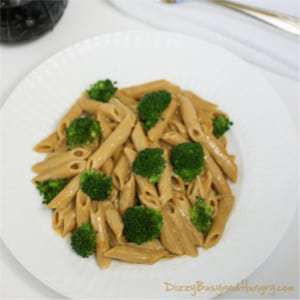 Overhead shot of broccoli penne with spicy peanut butter sauce on a white plate.