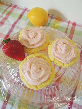 Overhead shot of strawberry lemonade cookies on a clear plate with a lemon and strawberry on the side. 