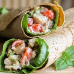 Side view of bacon blue cheese chicken wrap stacked on each other on a wooden surface.