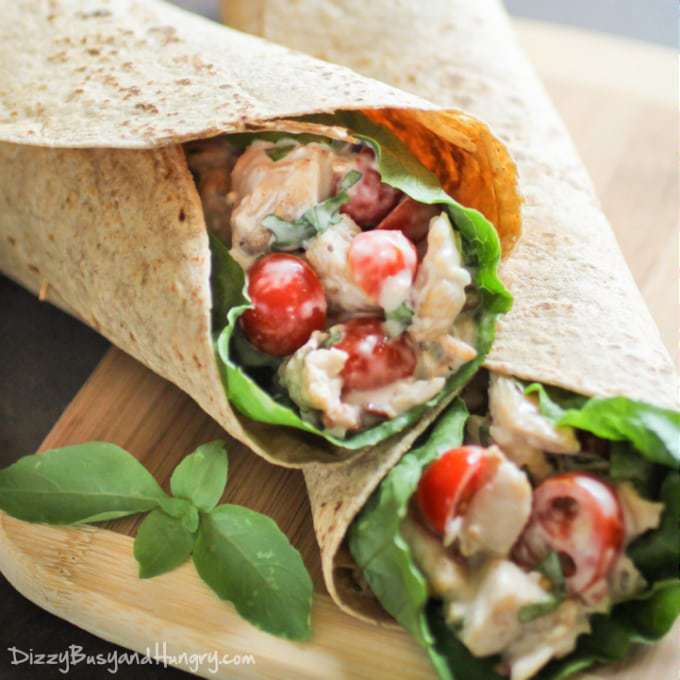 Side view of bacon blue cheese chicken wrap stacked on each other on a wooden surface. 