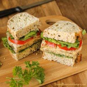 Side view of eggplant Milanese torta cut in half on a wooden cutting board.