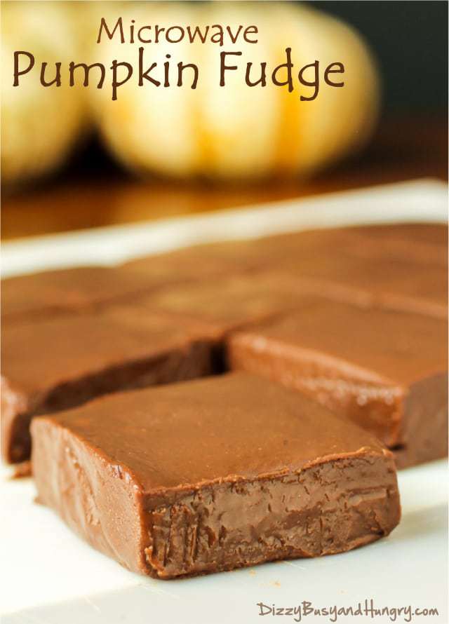 Side view of microwave pumpkin fudge squares on a white surface. 