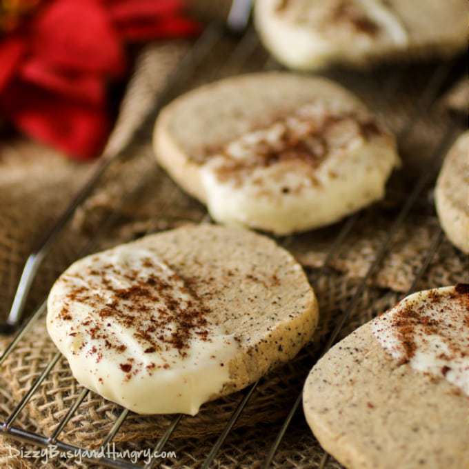 Close up shot of white chocolate dipped coffee shortbread cookies on a drying rack on a burlap cloth. 