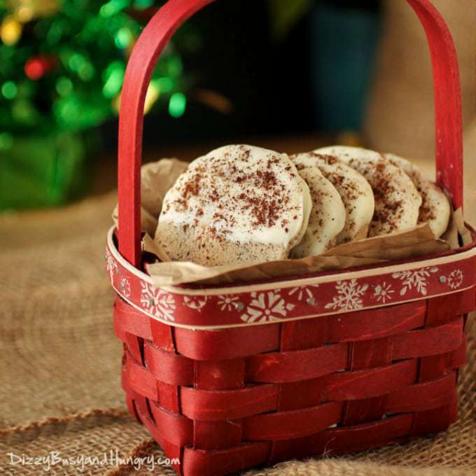Side view of a red basket filled with white chocolate dipped coffee shortbread cookies. 