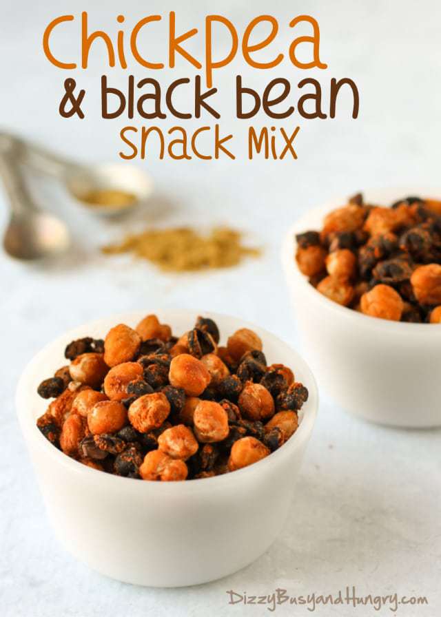 Close up shot of two white bowls of chickpea and black bean snack mix with spices in the background. 