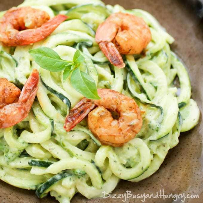 Close up shot of creamy avocado noodles with chipotle lime shrimp on a brown plate. 