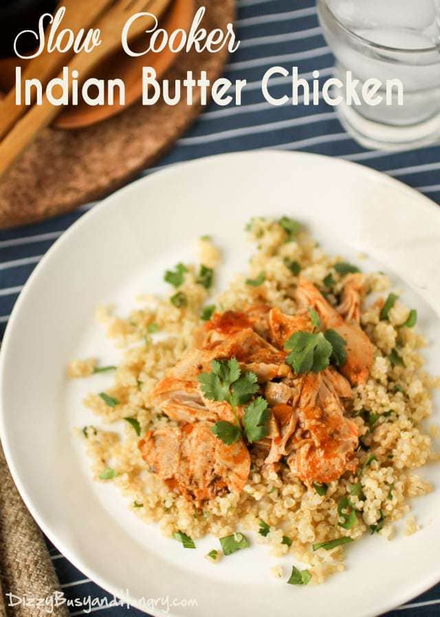 Overhead view of slow cooker Indian butter chicken on a white plate with a blue and white striped background. 