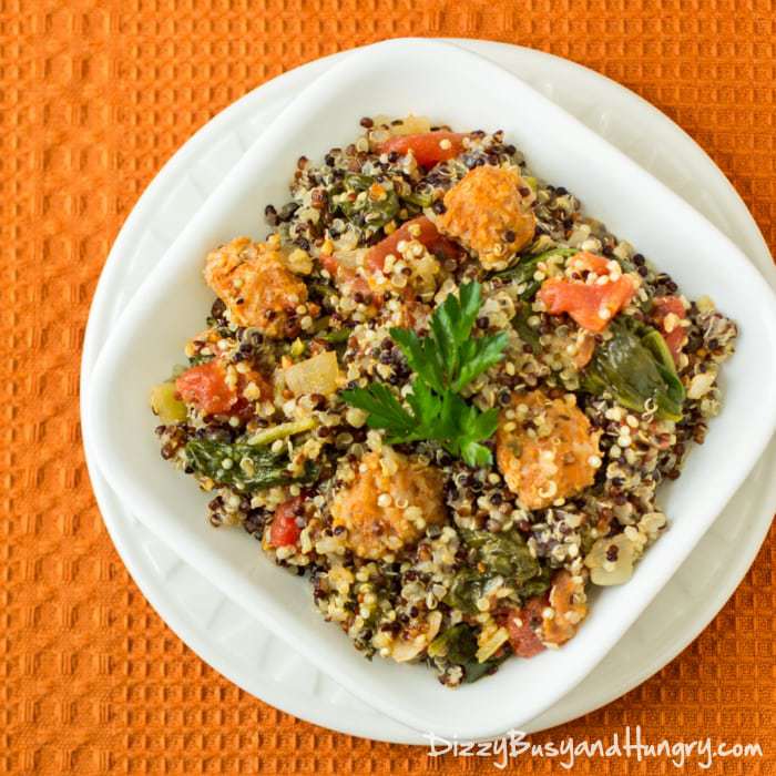 Overhead shot of chorizo and quinoa in a white bowl on a white plate on an orange cloth.