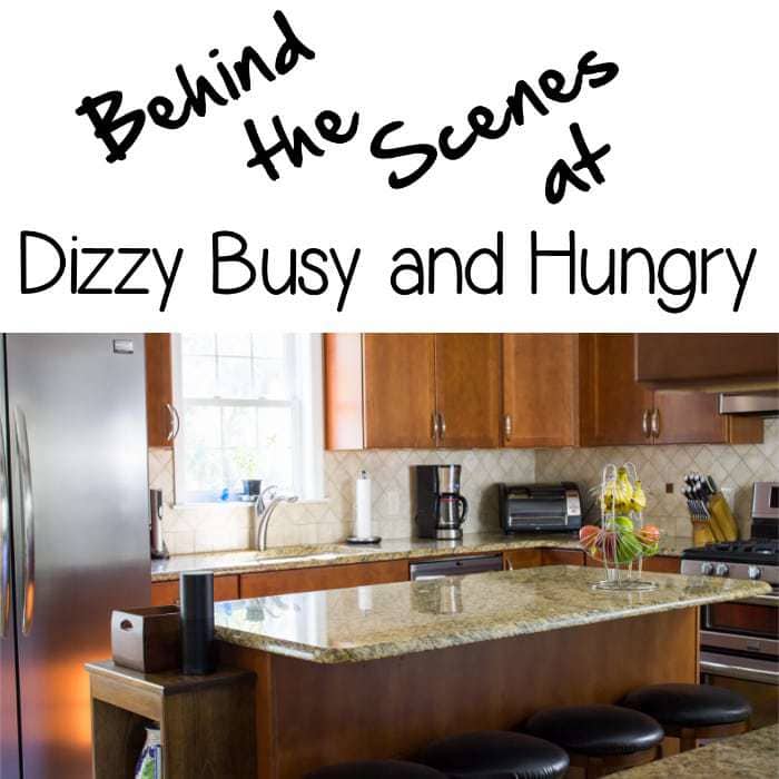 Side view of a kitchen with brown cabinets with the words "Behind the Scenes at Dizzy Busy and Hungry" written above.