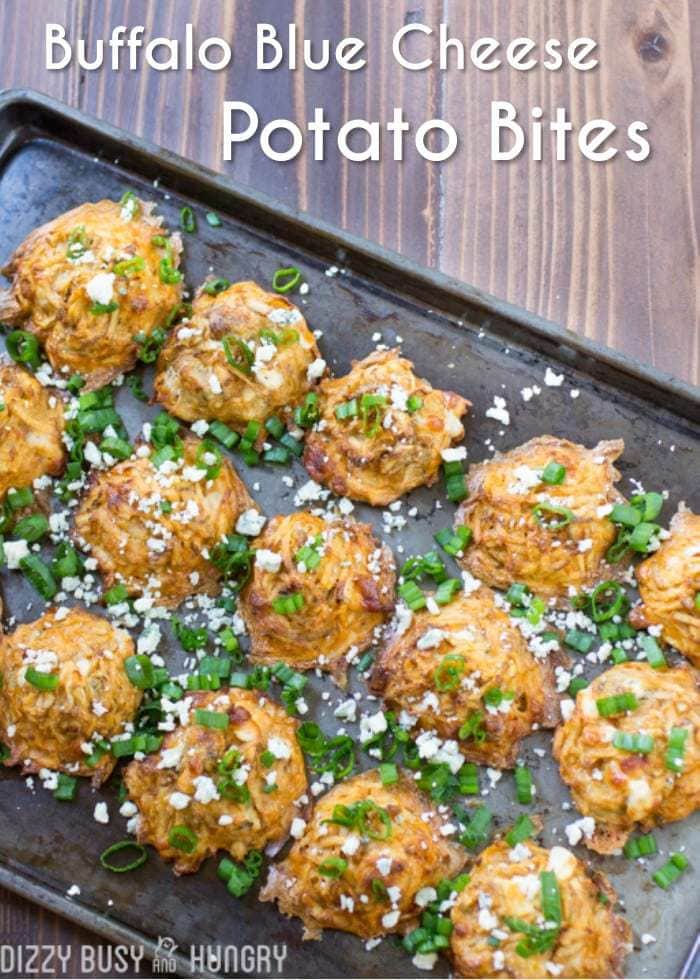 Overhead shot of buffalo blue cheese potato bites lines on a black baking sheet. 