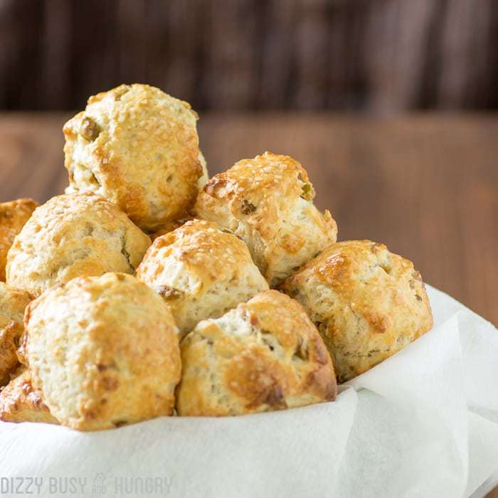 Close up shot of olive and parmesan pretzel bites in a bowl lines with a white cloth. 