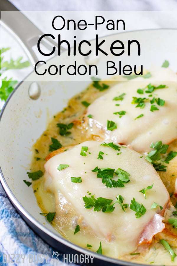 Side view of chicken cordon bleu in white skillet garnished with herbs. 