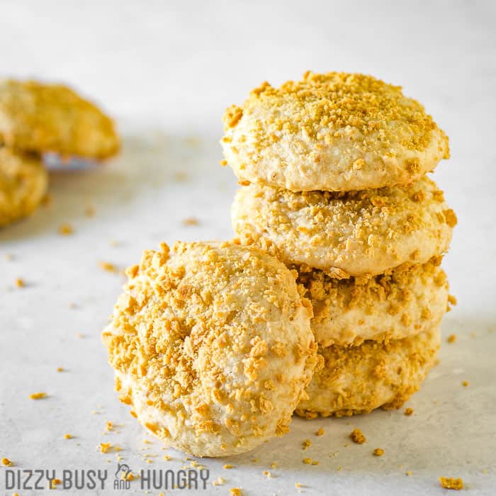 Side view of multiple banana graham cookies stacked on a white surface.