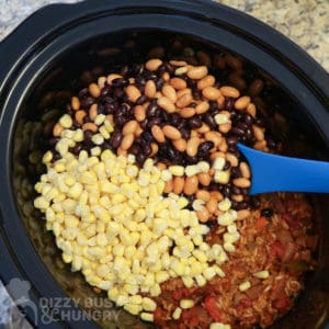 Close up view of process shot- crock pot with corn and beans added. 