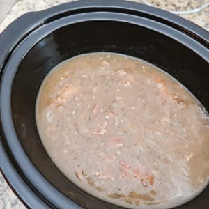 Close up view of process shot- creamy, thickened sauce in the crock pot. 