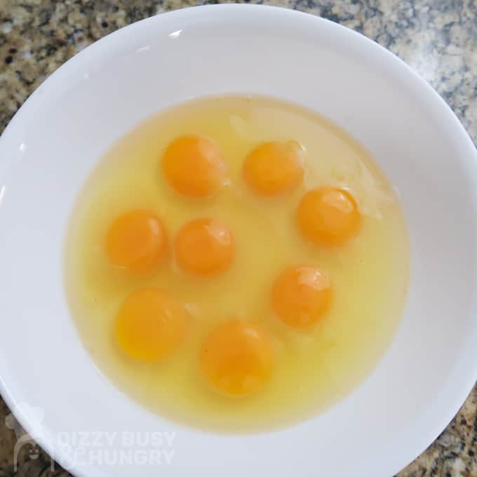 Overhead view of 8 eggs in a medium bowl ready to be whisked