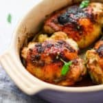 Oven Roasted Chicken Thighs in a white casserole dish - Cheap Chicken Recipes