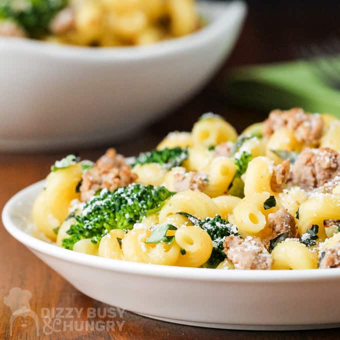 Side close up view of spiral pasta, fresh broccoli, and cooked ground turkey on a white plate.