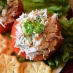 Closeup view of chicken stuffed tomato and with crackers on the side