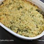 Top view of chicken broccoli in an oval casserole dish on a black background - cheap chicken recipes