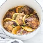 Top view of chicken, lemon and oranges in a white pan - Cheap Chicken Recipes