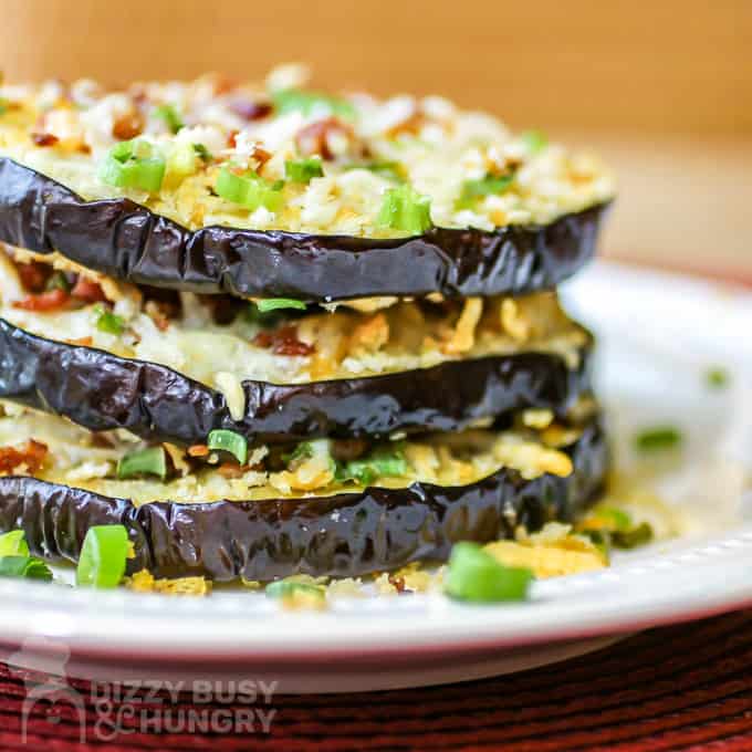 Side view of three stacked eggplant rounds on a white plate