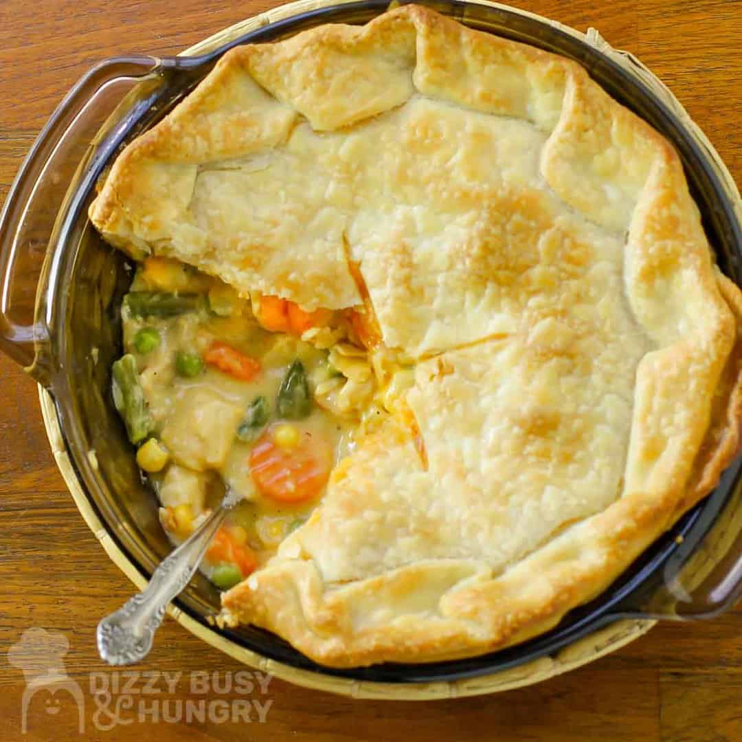 Overhead shot of chicken pot pie with slice taken out, left in the pan, with a fork.