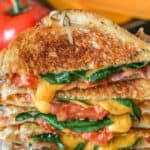 Front view of BLT grilled cheese sandwich halves stacked on top of one another
