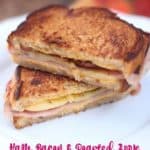 Front view of 2 ham and bacon grilled cheese sandwich halves stacked on top of one another on a white plate