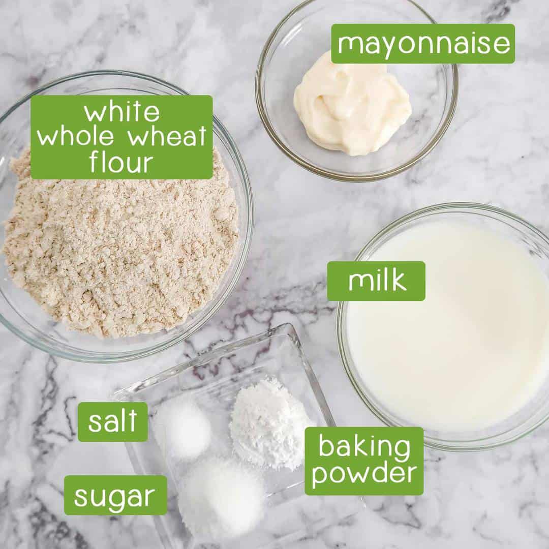 Overhead shot of ingredients- mayonnaise, white whole wheat flour, milk, baking powder, salt, and sugar.