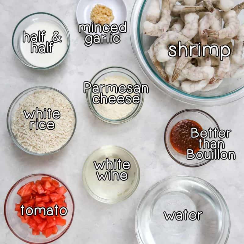 Overhead shot of labeled ingredients- half & half, minced garlic, shrimp, parmesan cheese, white rice, white wine, better than Bouillon, tomato, and water.