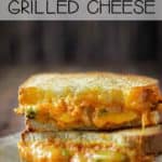 Front view of stacked grilled cheese with pumpkin and cheddar oozing out.
