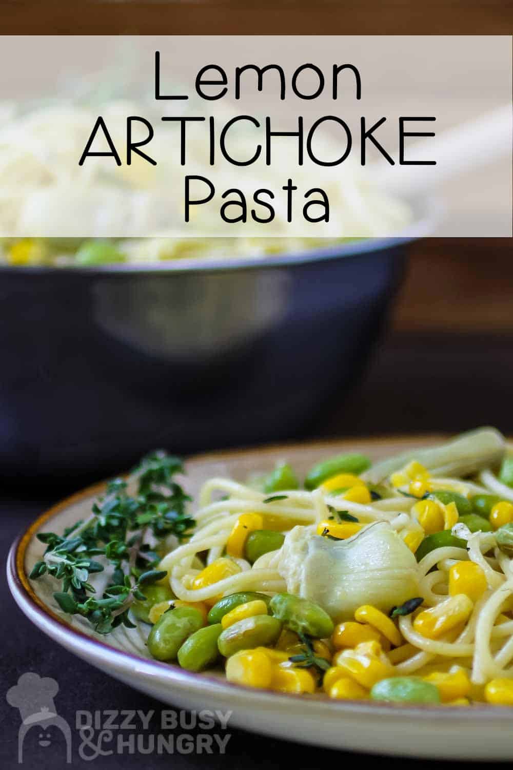 Front view of spaghetti, corn, artichoke on a plate garnished with a sprig of fresh thyme.