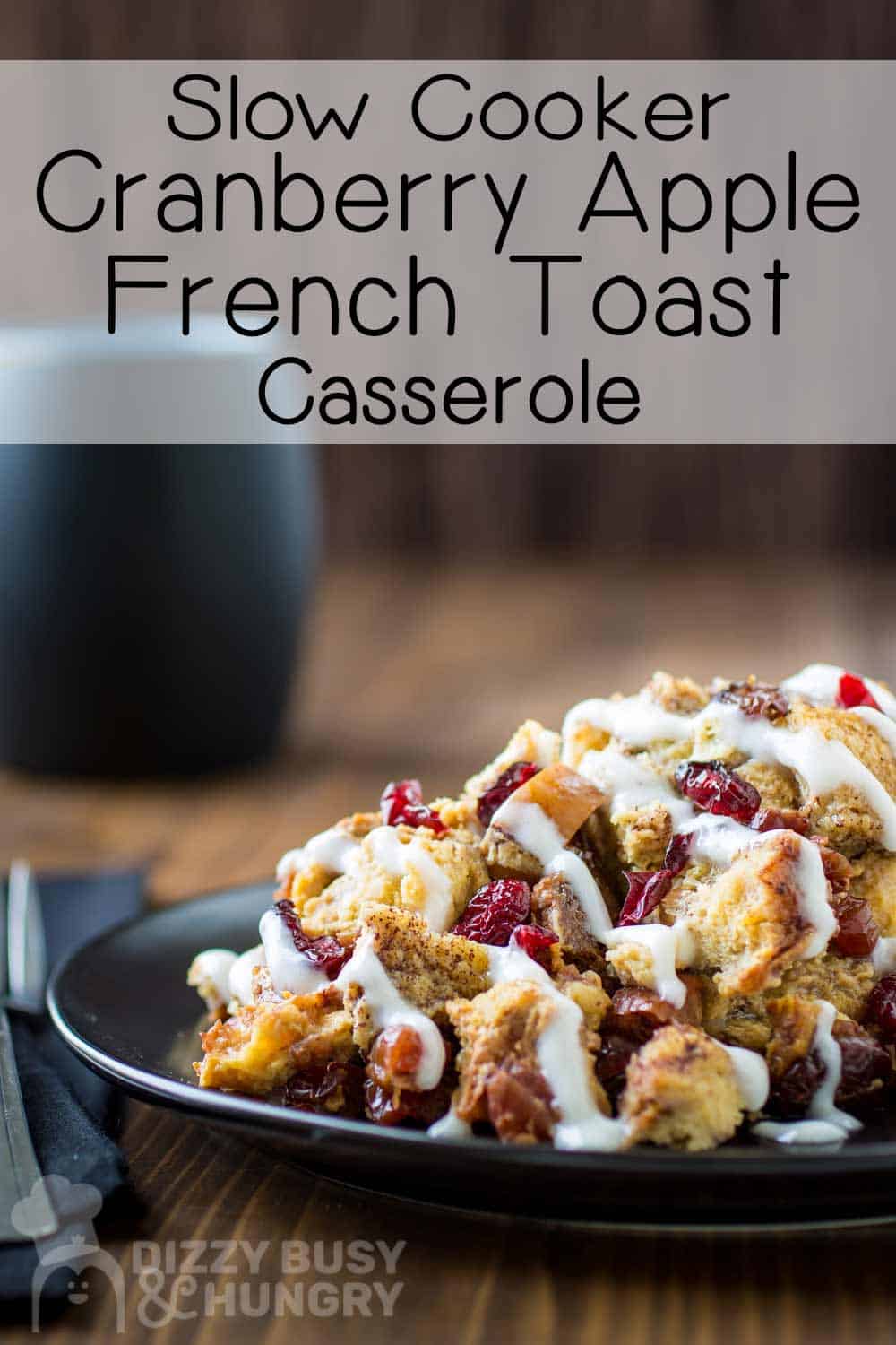 Side view of crock pot French toast casserole on a black plate on a wooden surface with a fork and a black napkin on the side.