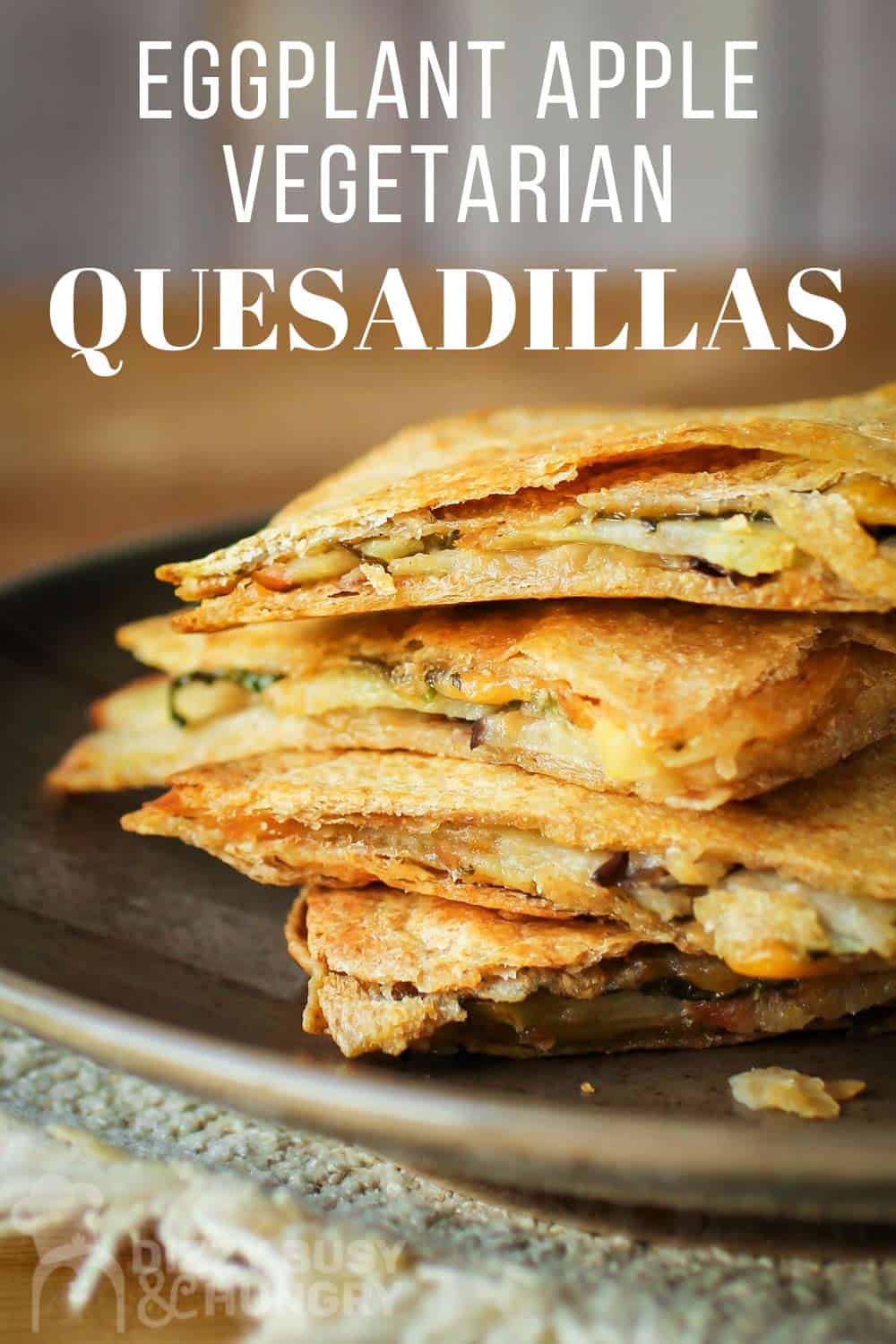 Close up shot of vegetarian quesadillas stacked on a brown plate.