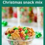 Side view of Christmas snack mix in a white bowl with gift bows scattered around on a white table, with more jars of he snack mix in the background.