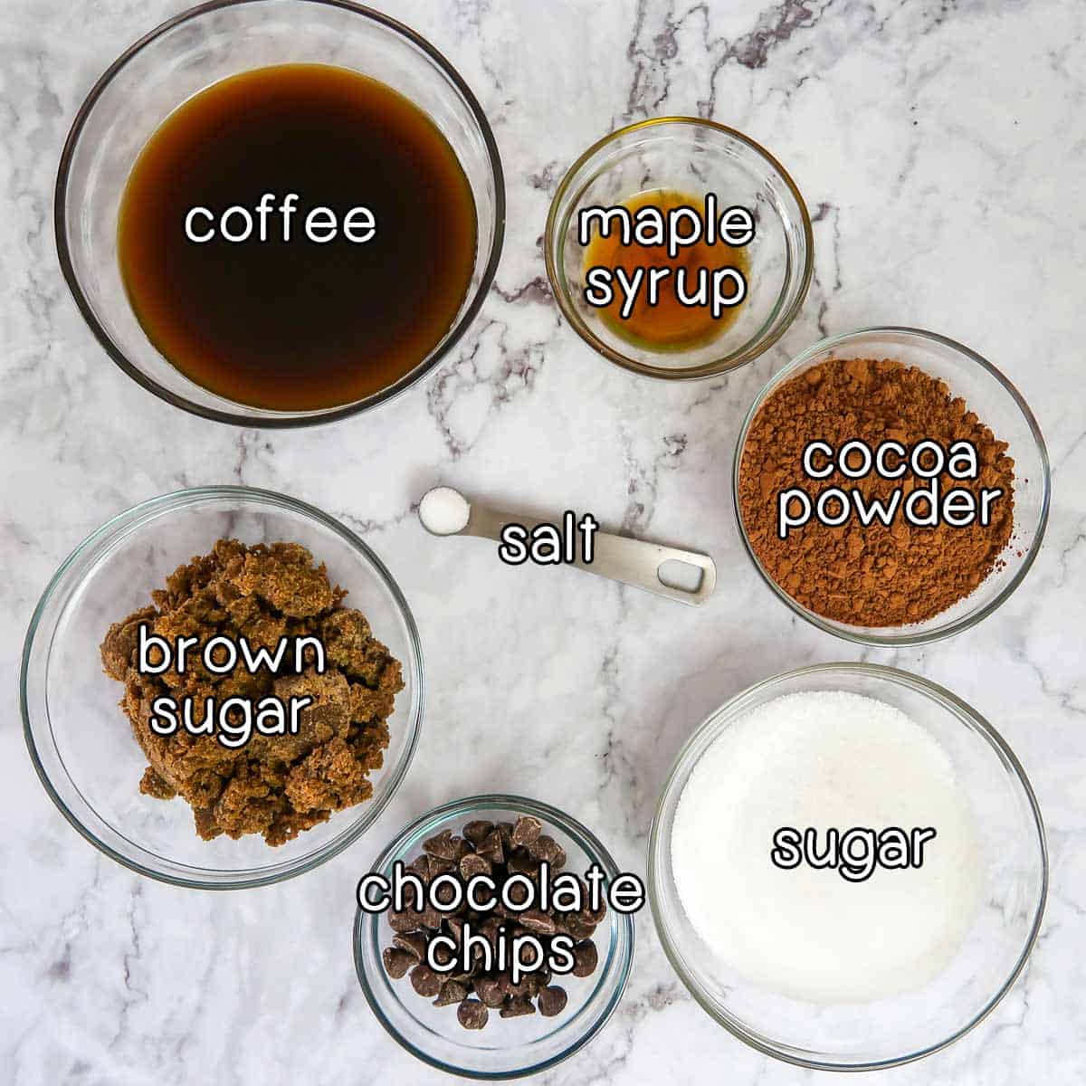 Overhead shot of ingredients- coffee, maple syrup, cocoa powder, sugar, chocolate chips, brown sugar, and salt.