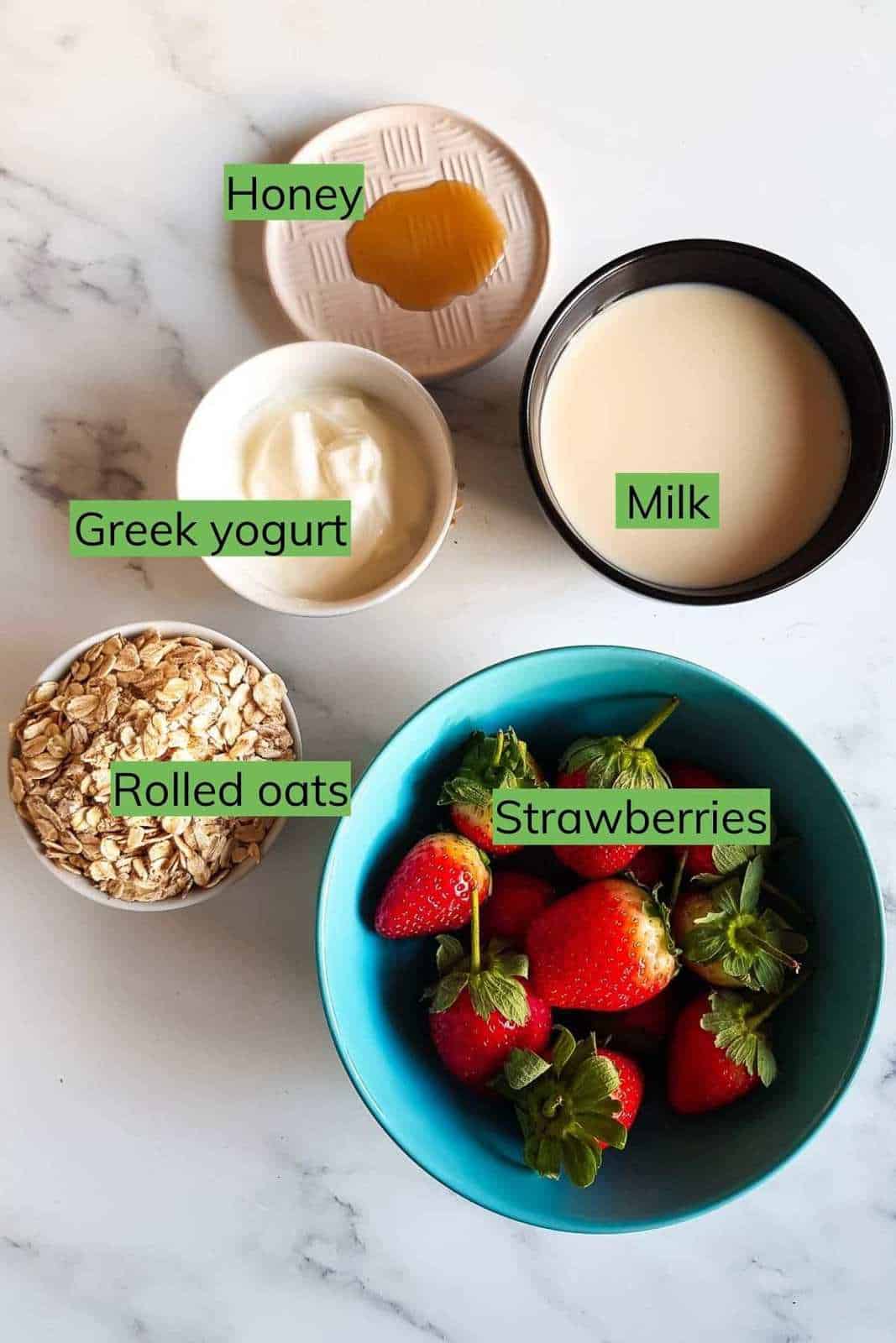 All the ingredients needed to make strawberry overnight oats laid out on a table.