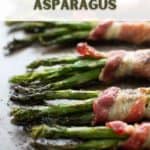 Cooked asparagus wrapped in bacon, lying on a tray.