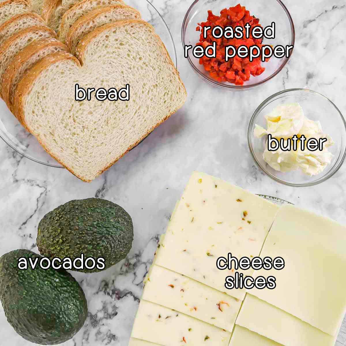 Overhead shot of ingredients- bread, roasted red pepper, butter, cheese slices, and avocados.