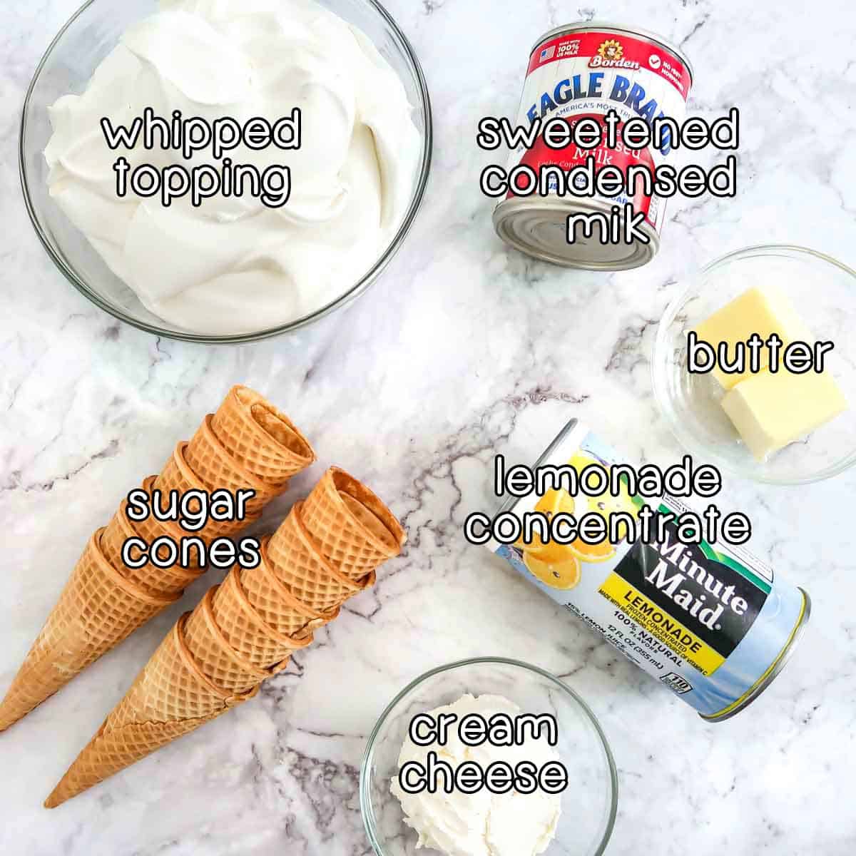 Overhead shot of ingredients- whipped topping, sweetened condensed milk, butter, lemonade concentrate, cream cheese, and sugar cones.