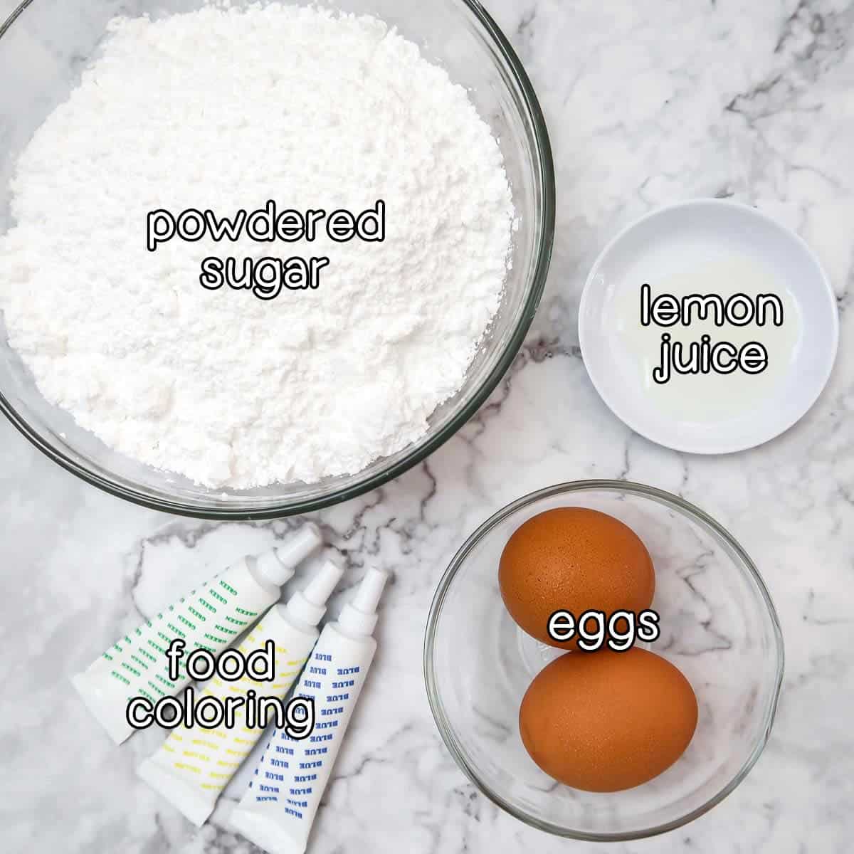 Overhead shot of ingredients list for icing- powdered sugar, lemon juice, eggs, and food coloring.