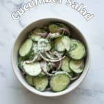 Cucumber salad in a whtie bowl.