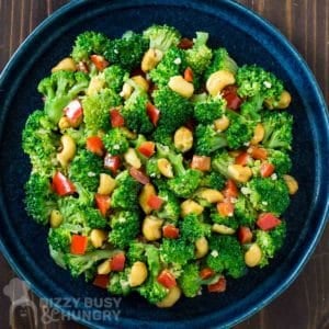 Overhead shot of garlic butter broccoli in a blue bowl on a wooden surface