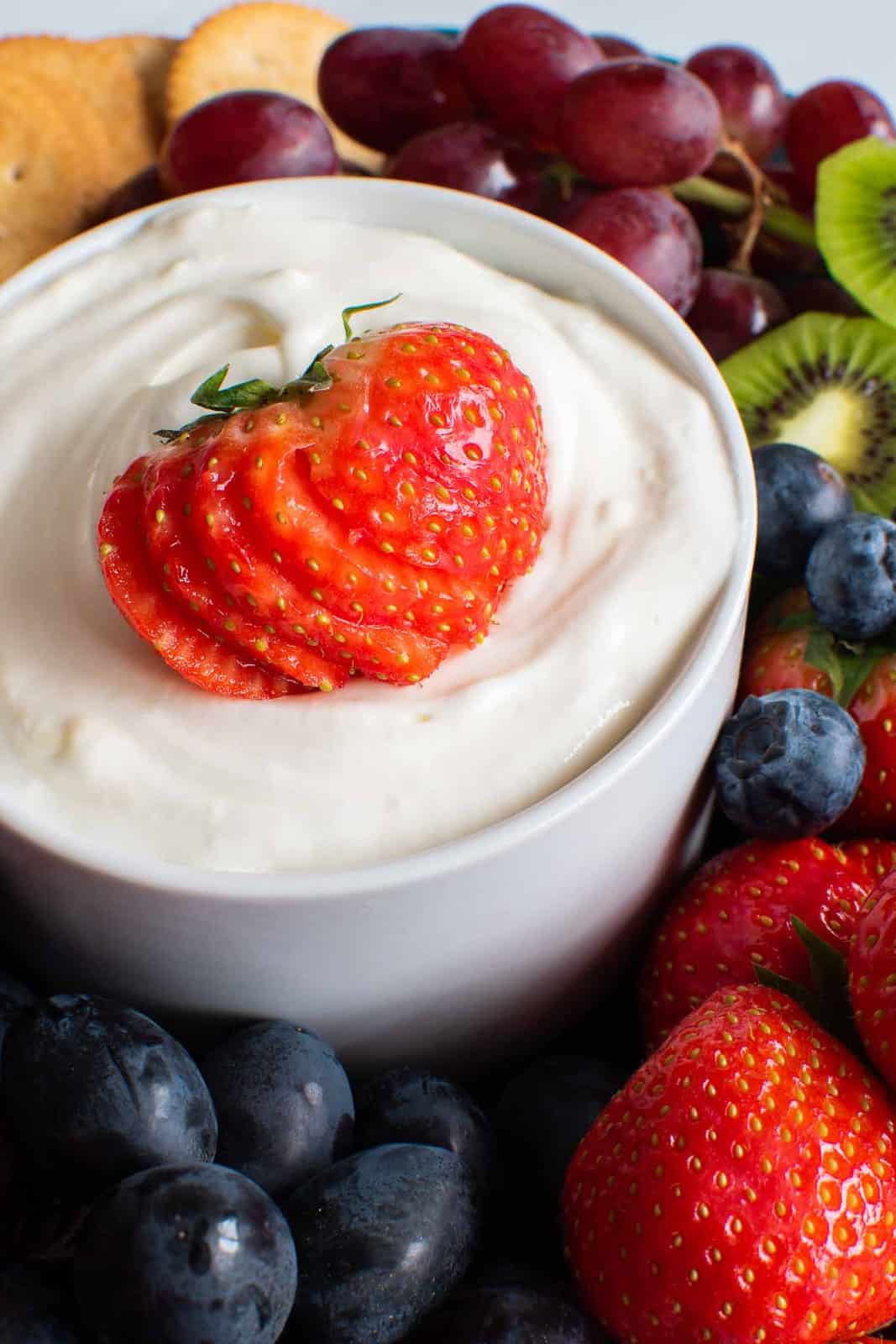 Sweet cream cheese dip with strawberries, blueberries, grapes and kiwi on the side.
