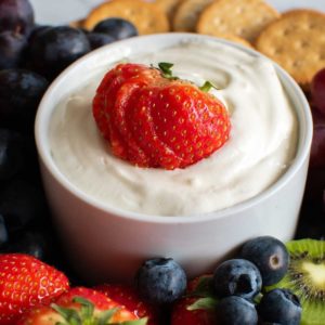Cream cheese fruit dip surrounded by fruit.