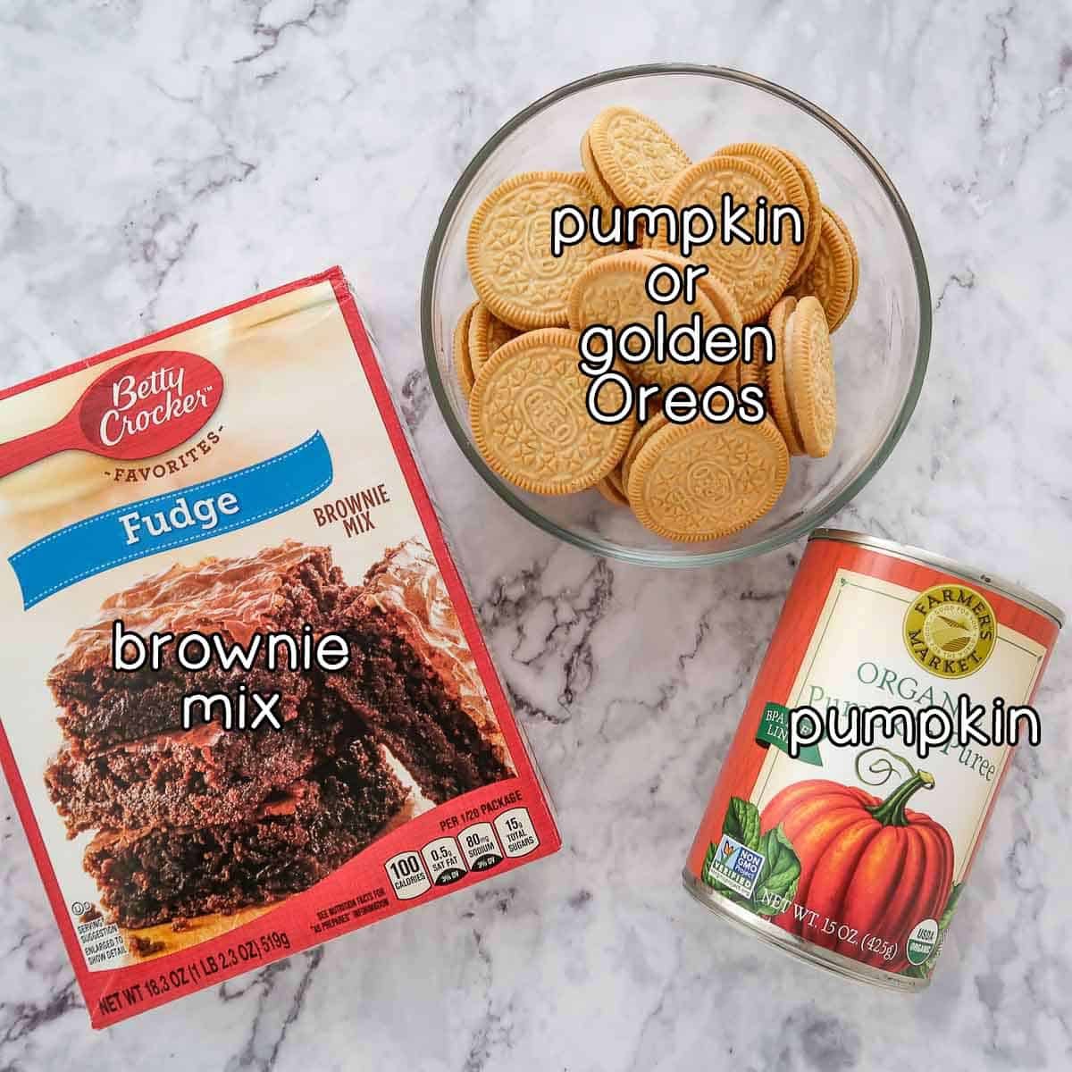 Overhead shot of ingredients- brownie ingredients, pumpkin or golden Oreos, and pumpkin.